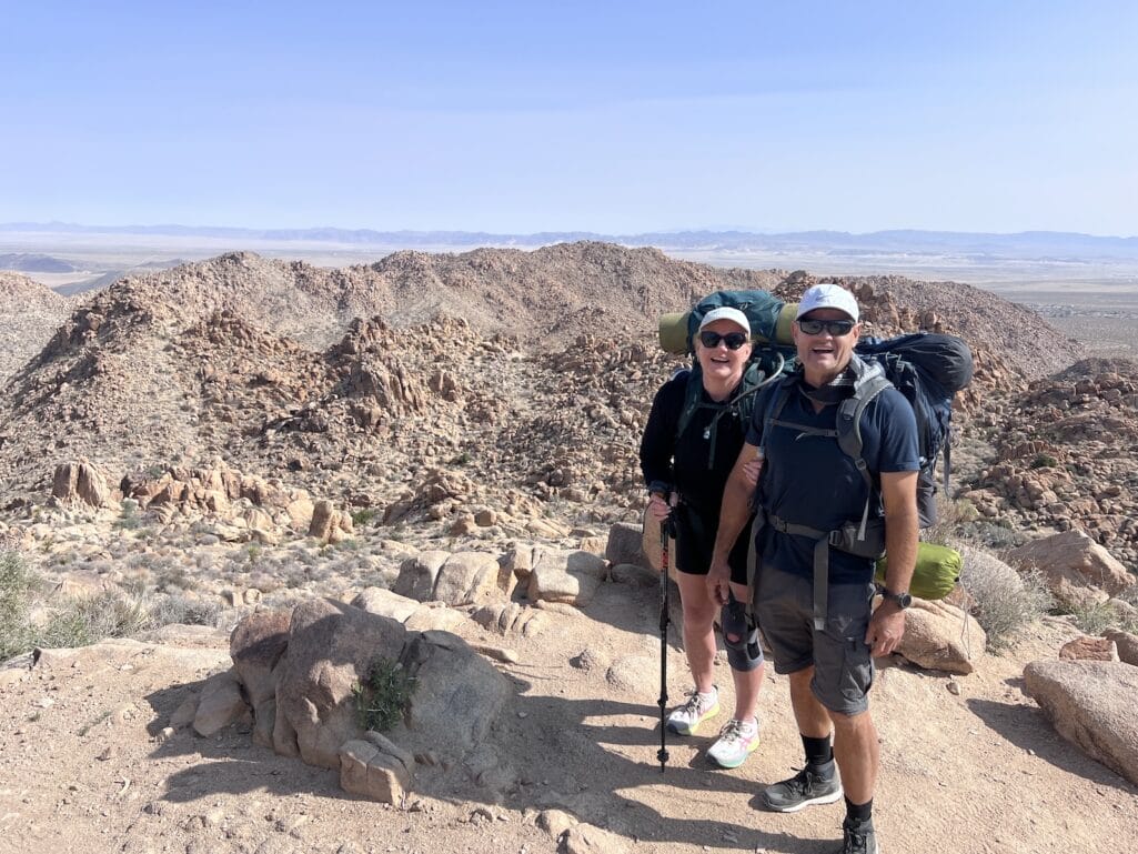 A couple in front of the wonderland of rocks. Boyscout trail hike in Joshua Tree.